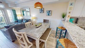 Una cocina moderna con una mesa de comedor de madera, armarios blancos y un ventanal grande.