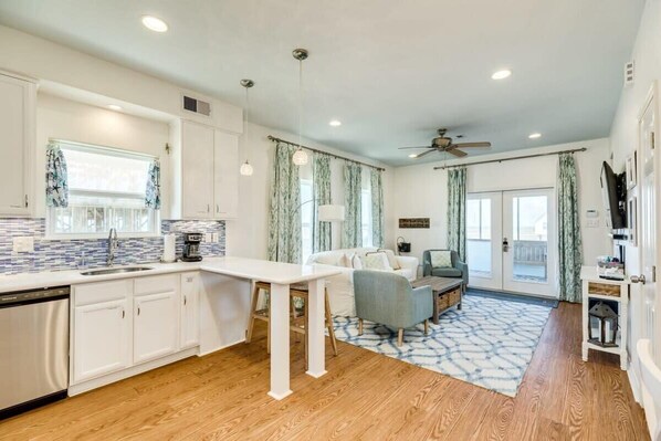 Enjoy a spacious kitchen and living area with a dishwasher, dining table, and comfortable couch.