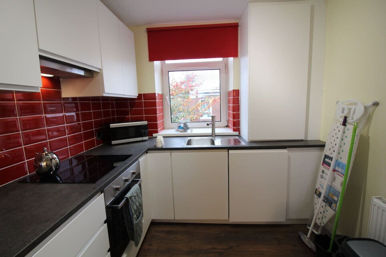 A compact kitchen with a microwave, stove, and sink.