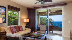 A room with a sofa, chairs, a coffee table, and a balcony with a view of the ocean. - Ocean Front!  Includes Waikoloa Golf Membership Benefits. Halii Kai 13A (Waikoloa Beach Resort)