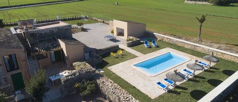 Une villa dotée d’une piscine, d’un espace extérieur aménagé et offrant une vue sur les champs environnants.