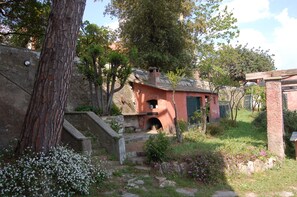 Un bâtiment de style rustique, avec une façade en briques, une cheminée et une petite entrée en arc de cercle.