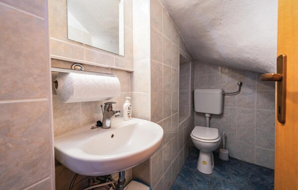 A small bathroom with a white sink, toilet, and a mirror above the sink. - 2 bedroom stunning home in Marcenagla (Marcenagla)