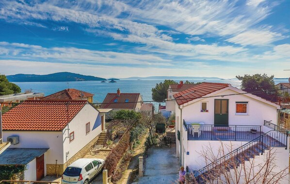 A coastal residential area with terracotta-roofed houses, a narrow street, and a view of the sea and distant islands. - 2 bedroom beautiful apartment in Seget Vranjica (Seget Vranjica)