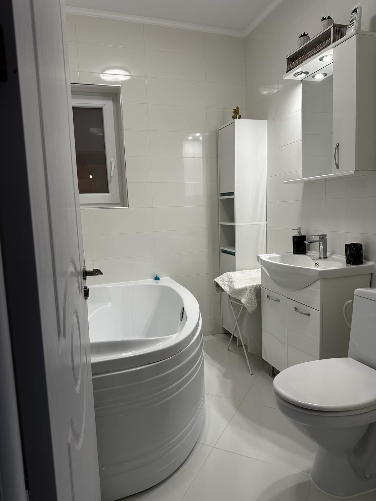 A modern bathroom with a freestanding bathtub, a toilet, and a sink.