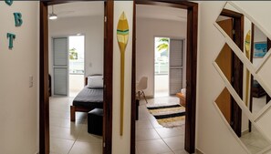 Relax in a spacious room with a large bed, balcony views, and a separate entrance to another room.