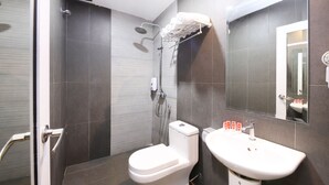 A modern bathroom with a shower, toilet, and sink.