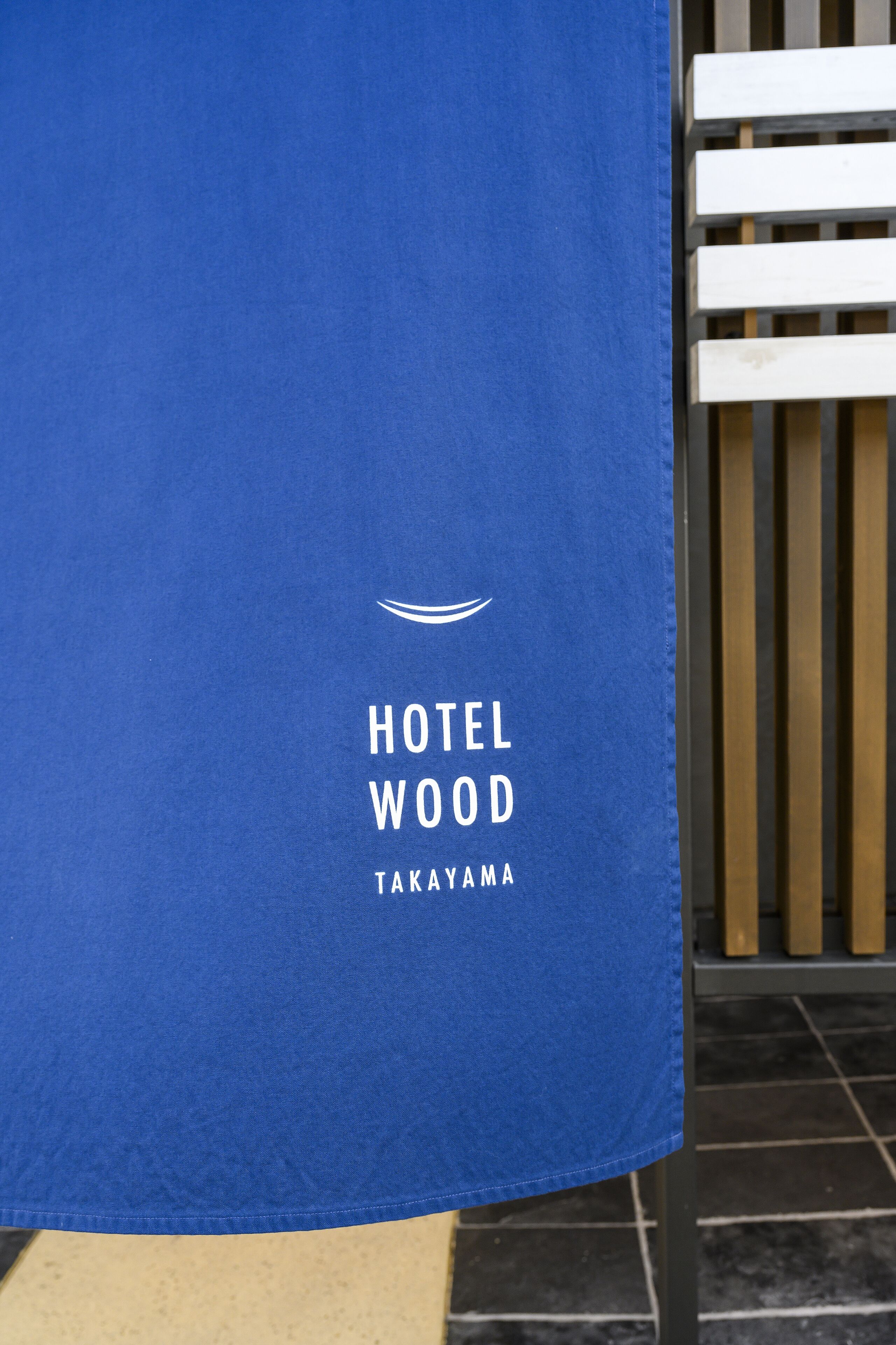 A blue towel with "HOTEL WOOD TAKAYAMA" printed on it.