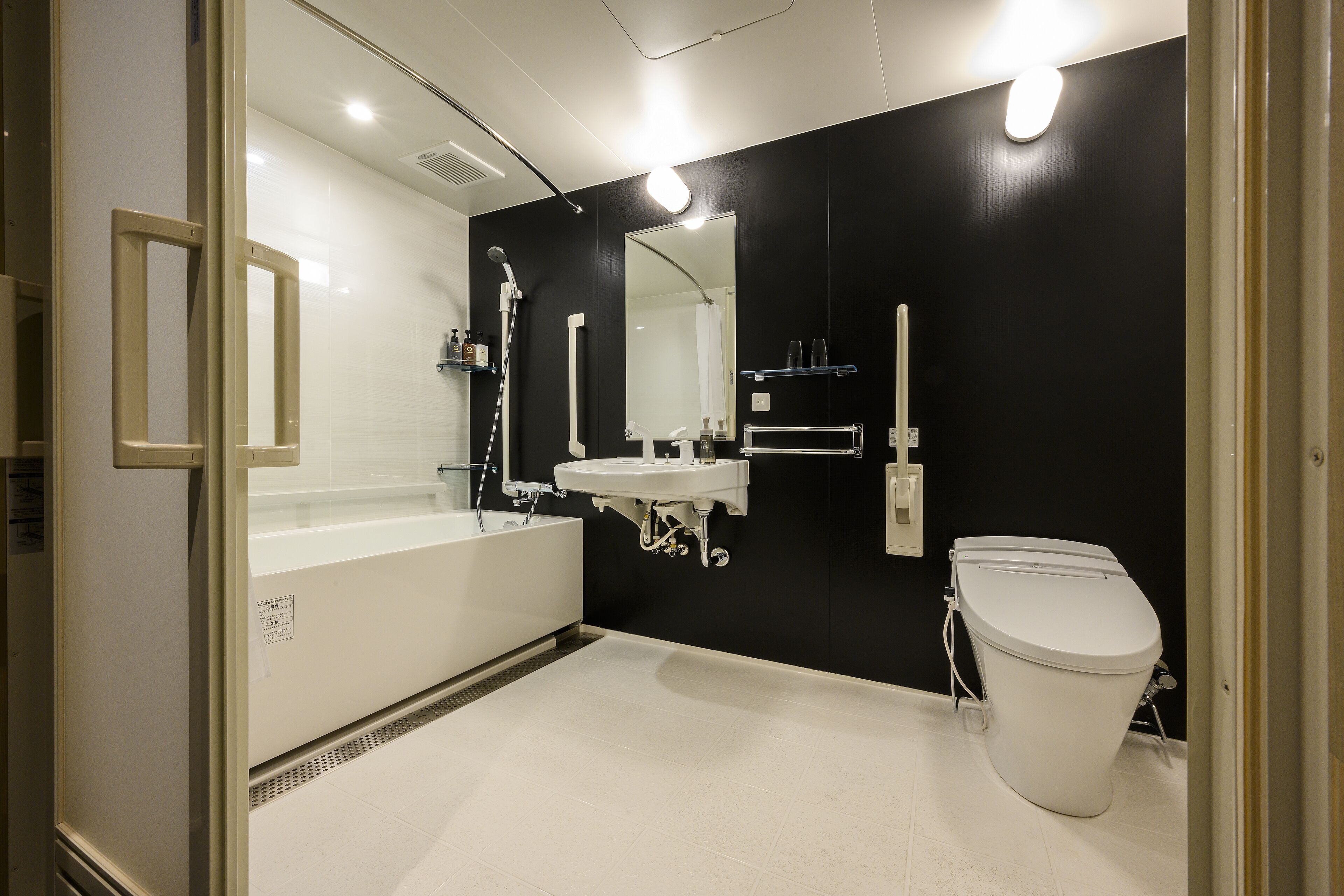 Een moderne badkamer met een bad, wastafel en toilet.