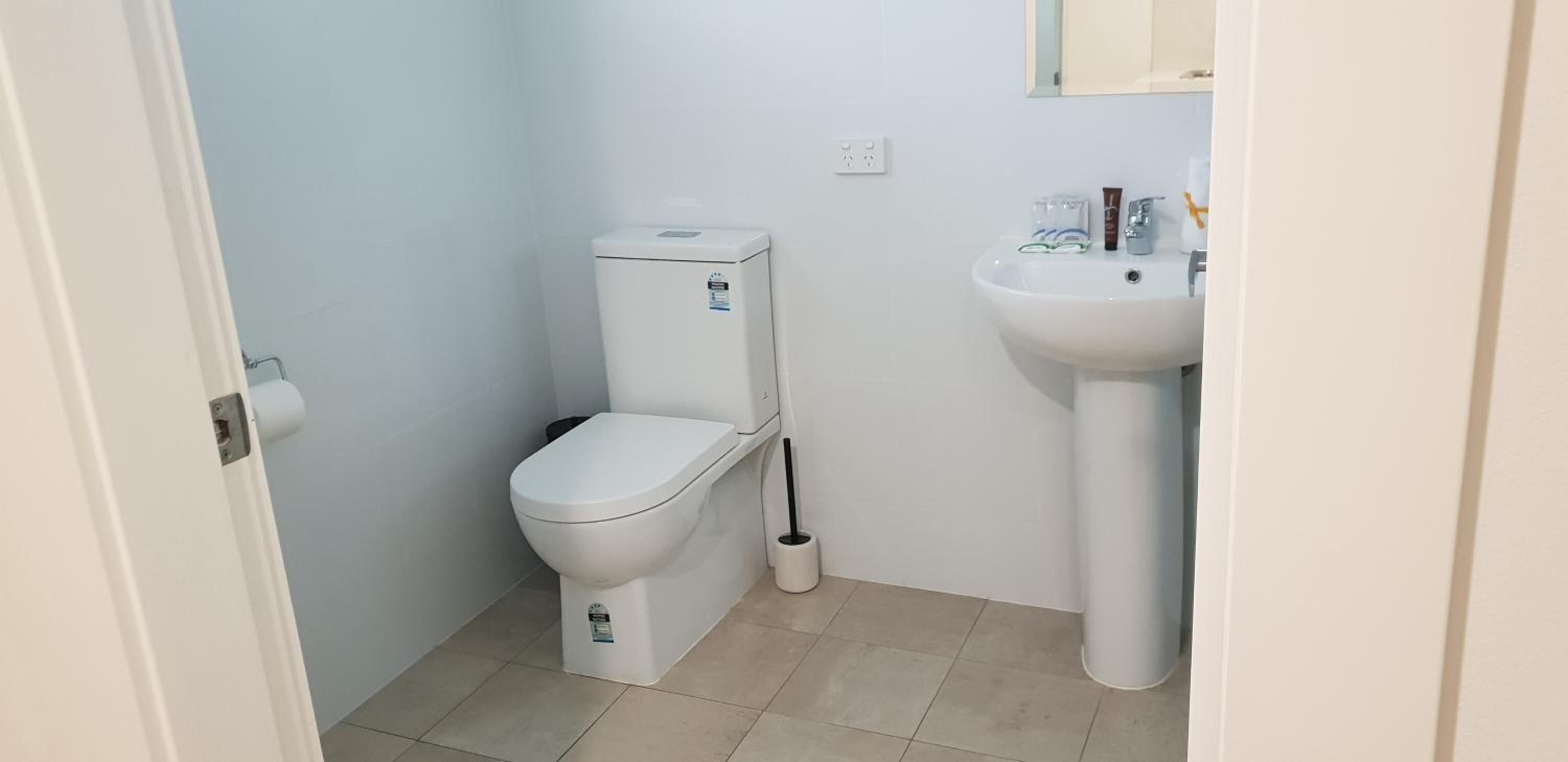 A small, clean bathroom with a toilet, bidet, and sink.