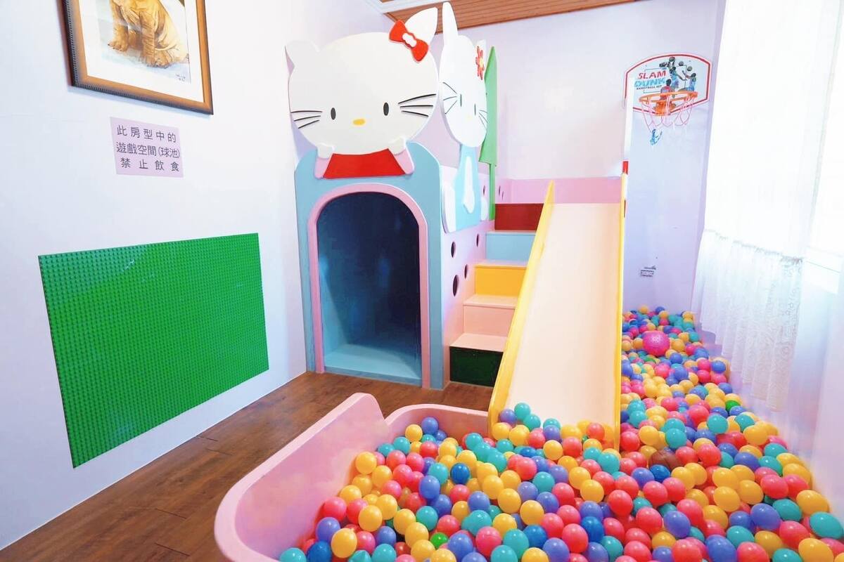 A children's play area with a ball pit, a slide, and a Hello Kitty decoration.