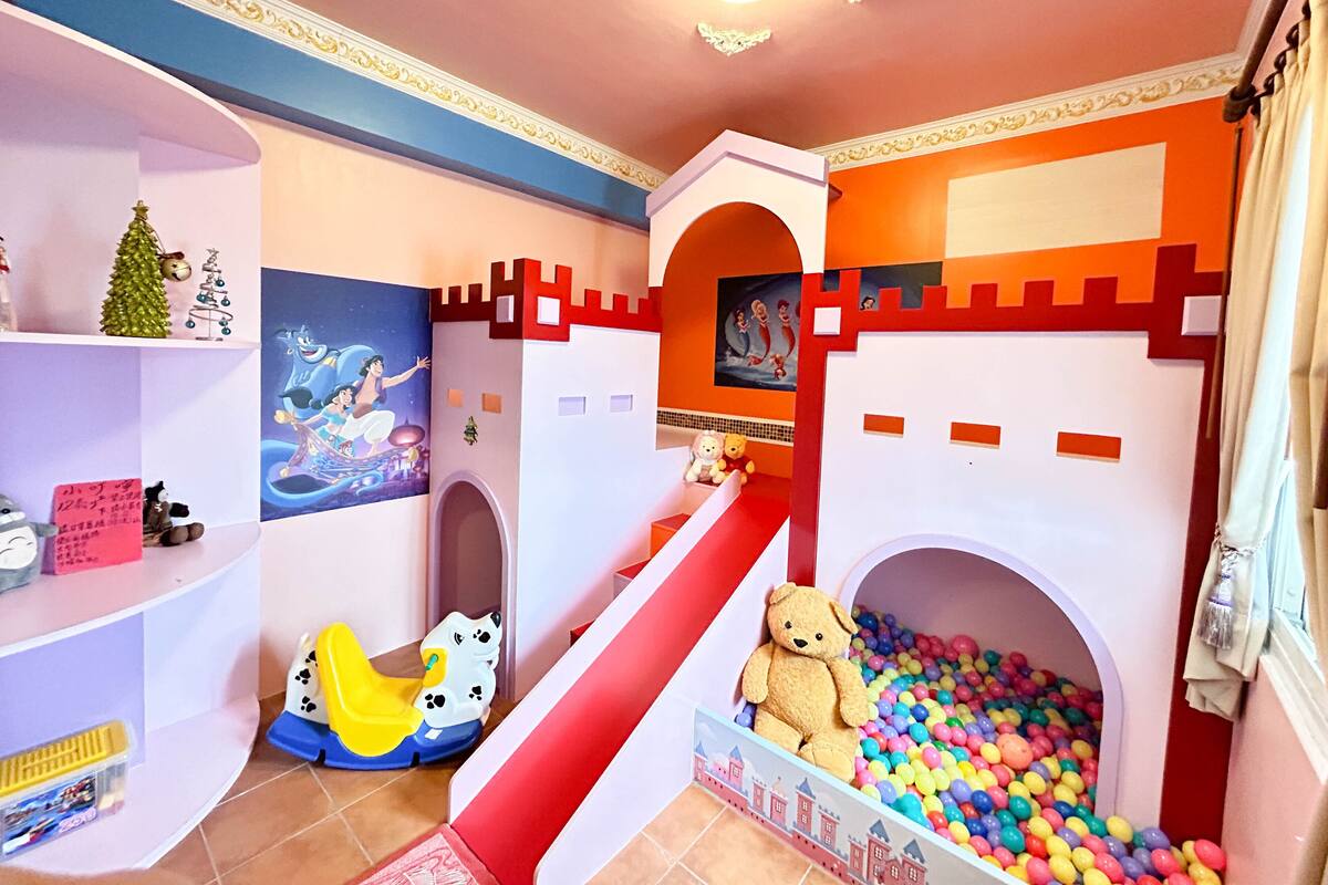 A children's play area with a slide, ball pit, and castle-themed decorations.