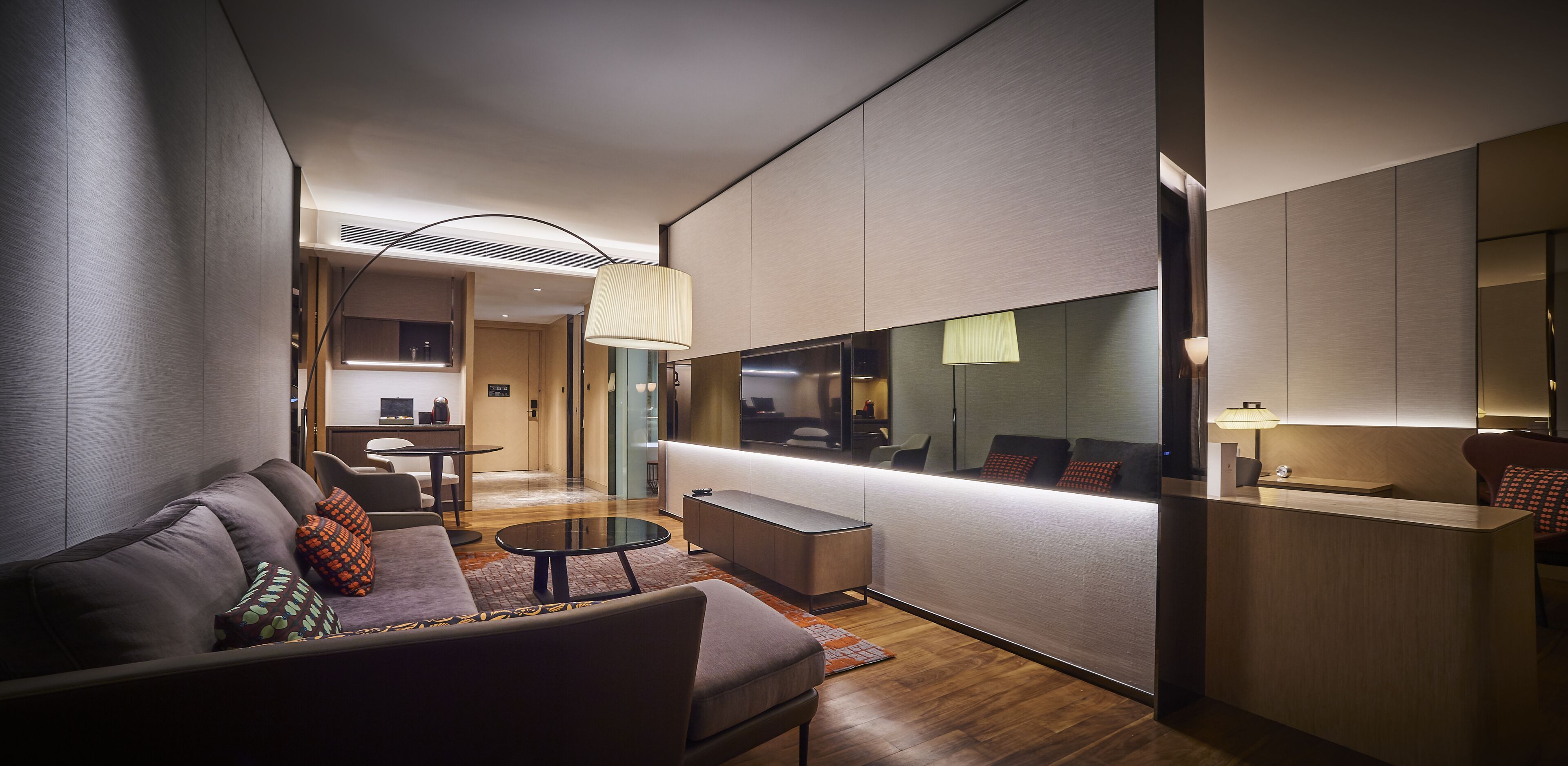 A modern hotel lobby with a sofa, coffee table, and a reception desk.