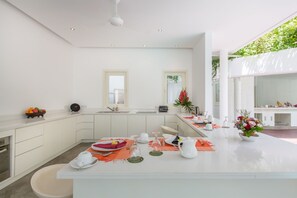 Enjoy meals in this stylish kitchen and dining area, featuring a central island, natural light, and a dining table for six.