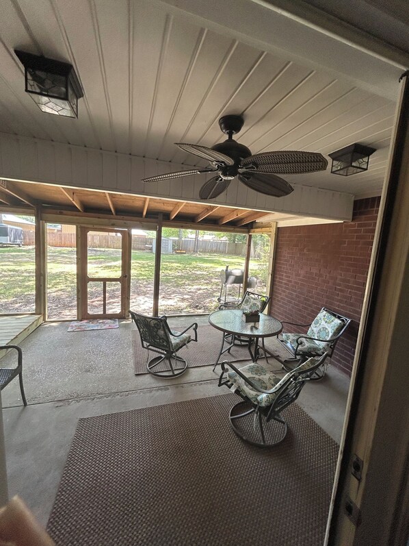 A covered patio area with a ceiling fan, outdoor seating, and a view of the backyard. - Foley. 20 mins to beaches, close to Tanger Outlet, Owa, sports complex (Foley)