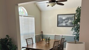A dining area with a wooden table, chairs, a ceiling fan, a lamp, and a framed picture on the wall. - Foley. 20 mins to beaches, close to Tanger Outlet, Owa, sports complex (Foley)