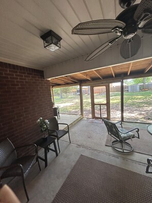 Relax in this patio area with a glass door leading to a serene outdoor space.