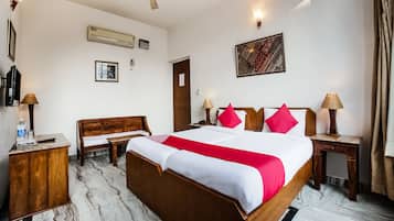 Relax in a spacious room with a large bed, wooden nightstand, and comfortable seating area.