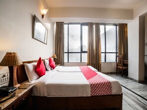 A hotel room with a large bed, two bedside tables, a desk, a chair, and a window with curtains. - OYO 27041 Hotel Luna Rosa (Jaipur)