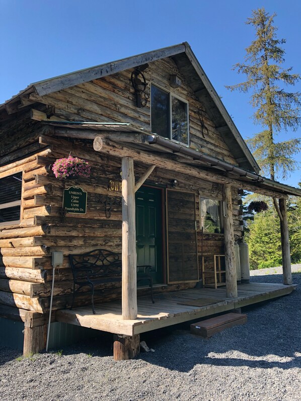 Experience the charm of Unrein's Upper Cabin, a traditional log cabin with a cozy entrance and inviting porch.