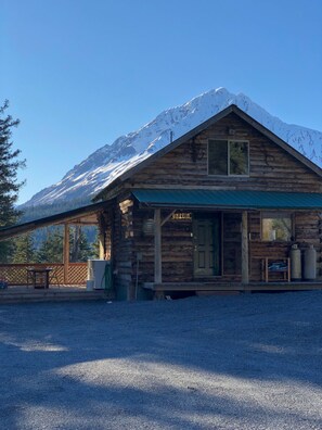 Escape to a secluded mountain retreat with a rustic cabin entrance and breathtaking mountain views.