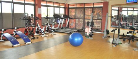 A gym with exercise equipment, a blue exercise ball, and a blue mat.