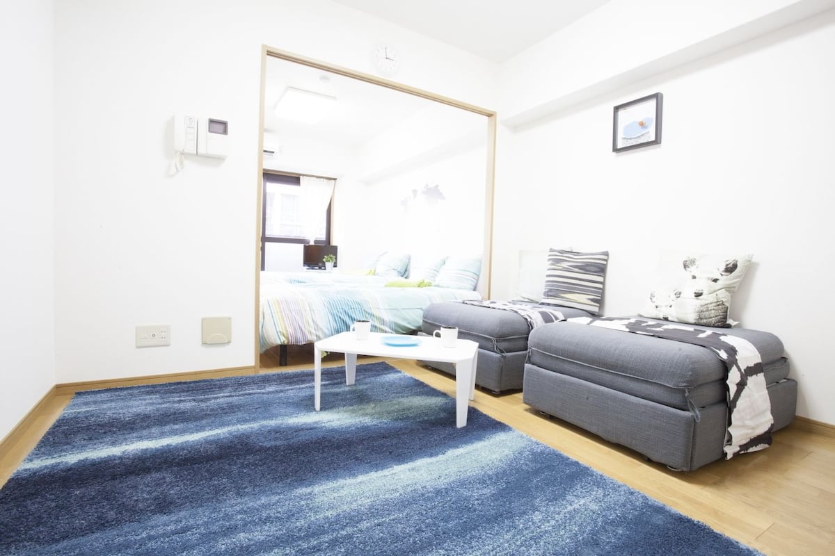 Een moderne slaapkamer met een bed, een bank, een bijzettafeltje en een grote spiegel.