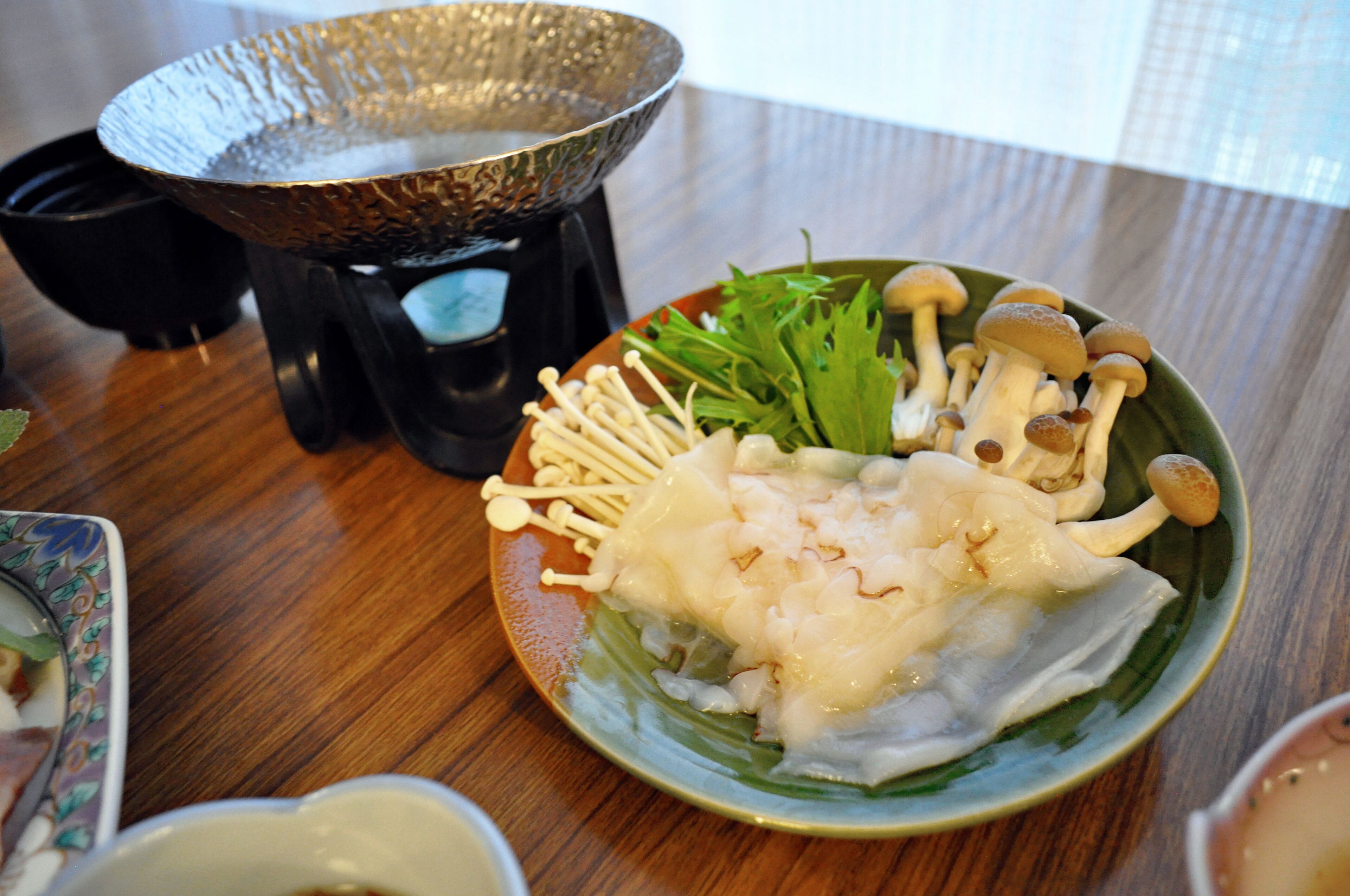 Un plato de comida con champiñones y vegetales sobre una mesa de madera.