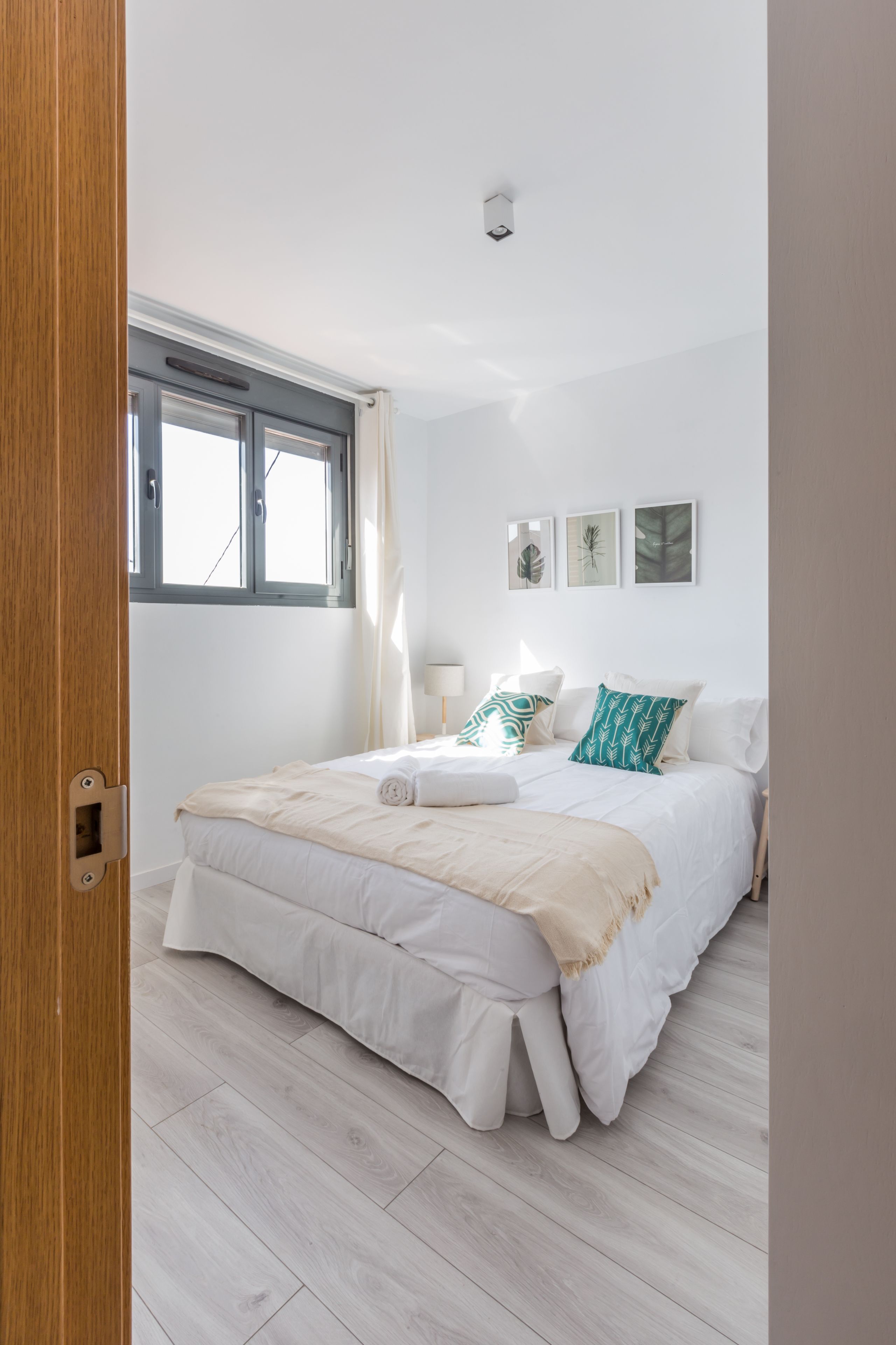 Un dormitorio con una cama, una ventana y una puerta.