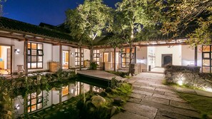 A traditional Japanese-style courtyard with a koi pond, stone pathways, and wooden structures. - Floral Hotel Songyang Niaoshe (Lishui)