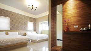 Una habitación de hotel moderna con dos camas, una pared decorada con ladrillos, una pared de paneles de madera y una pequeña mesa con un jarrón de flores.