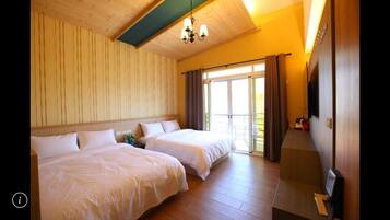 A hotel room with two beds, a TV, and a balcony with curtains.