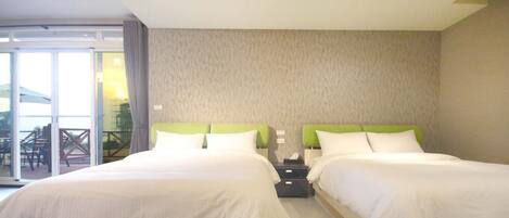 Habitación de hotel con dos camas, puerta corrediza de vidrio a un balcón y pared con diseño.