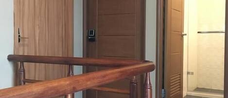 Uma escada de madeira leva a um quarto com uma porta identificada com o número 301.