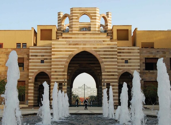 The American University in Cairo with a central archway and water fountains in front. - New Panorama Hotel (Cairo)