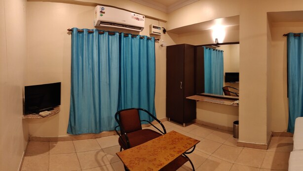 Una habitación de hotel con una cama, un escritorio, una silla y un televisor.
