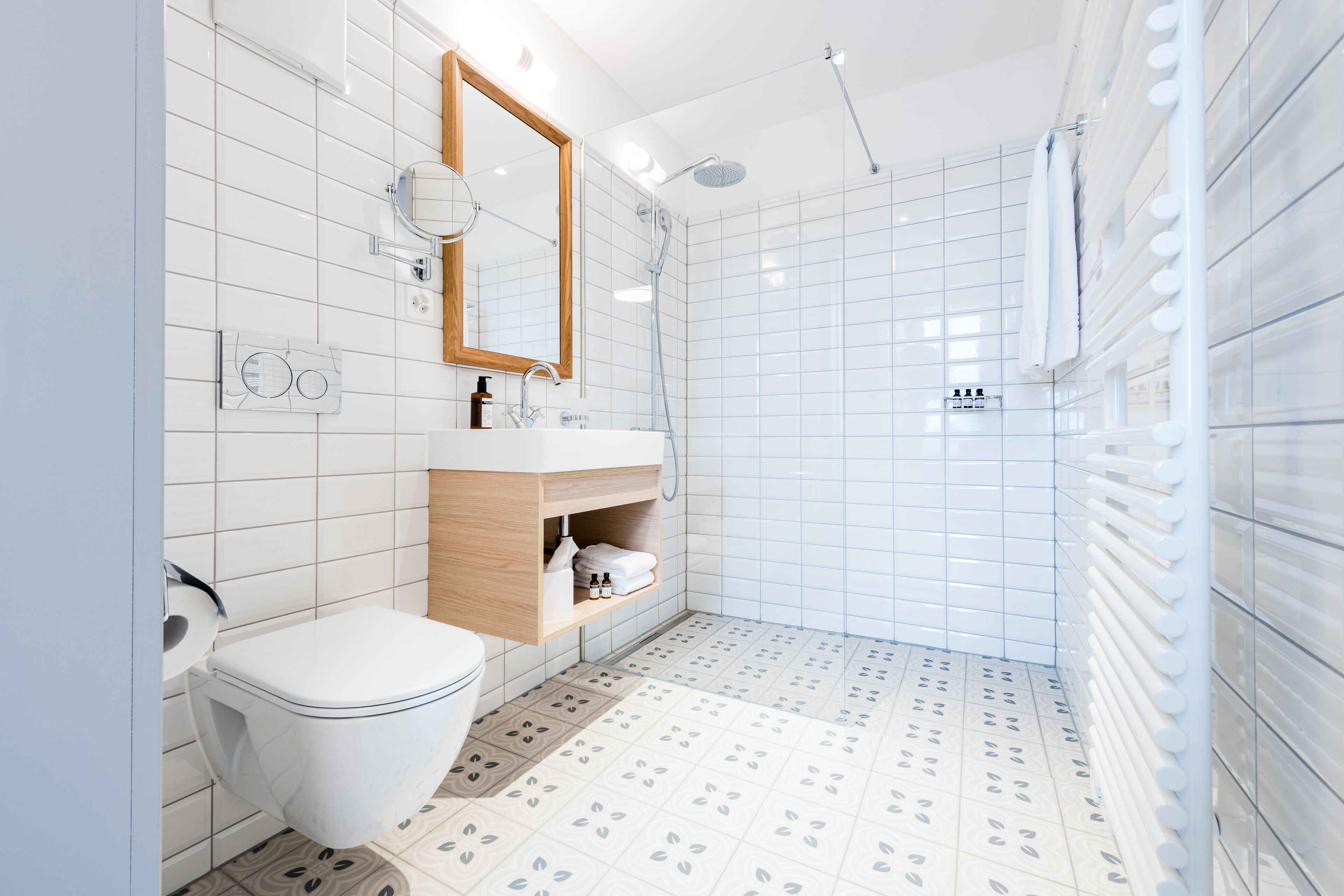 Een moderne badkamer met toilet, wastafel, spiegel en douche.