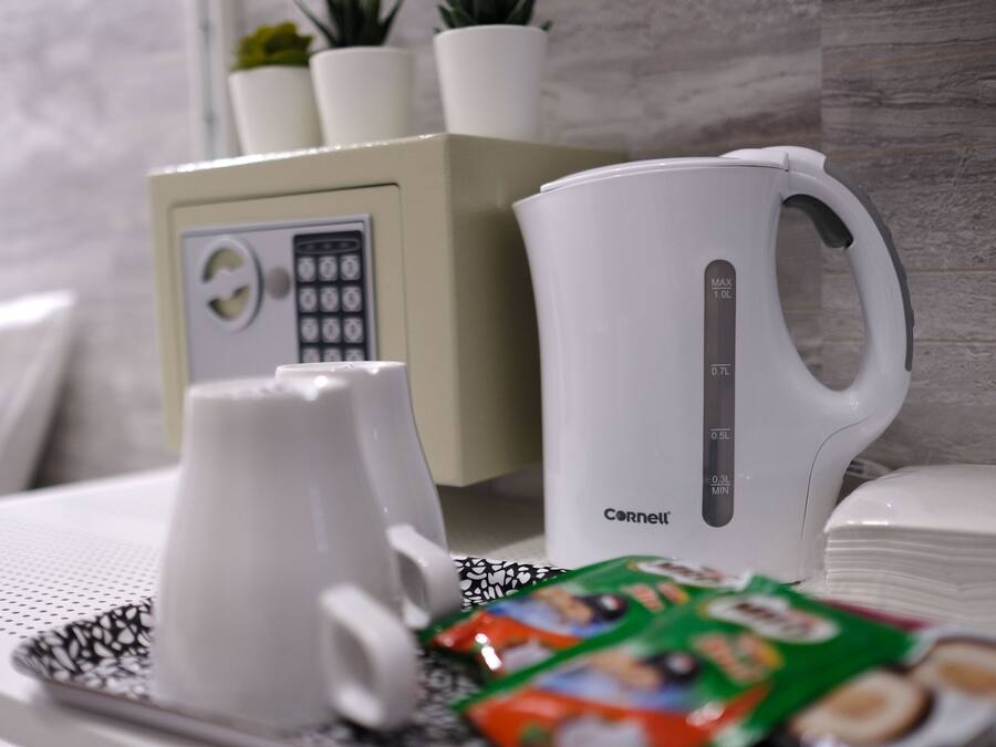 Uma cozinha com cafeteira, chaleira e uma bandeja com lanches.