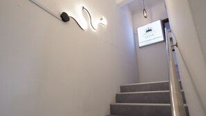 Uma escadaria com corrimão de metal e uma placa acima que diz 'Q Loft Hotel of Comfort and Choices'.