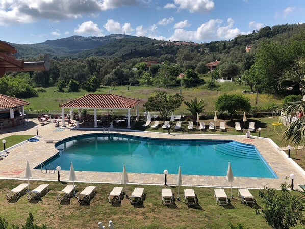 Una piscina al aire libre de temporada, sombrillas