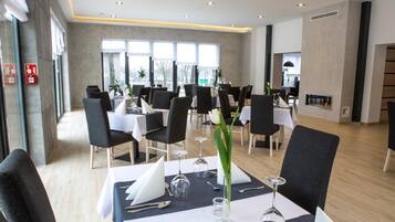 Un restaurante moderno con varias mesas dispuestas para comer, con una decoración interior limpia y contemporánea.