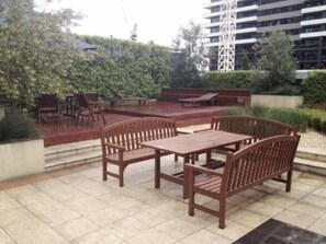 Relax in a serene outdoor space surrounded by lush greenery and comfortable seating.