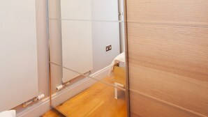 A modern bathroom with a glass shower enclosure, wooden flooring, and a white sink. - Camden Town Colorful Market Atmosphere (London)