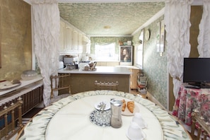 Classic kitchen with a central island, cabinetry, and a dining area for two.