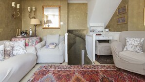 A cozy room with two white sofas, a patterned rug, a mirror, and a small table with candles. - Chelsea for History and Art Lovers (London)