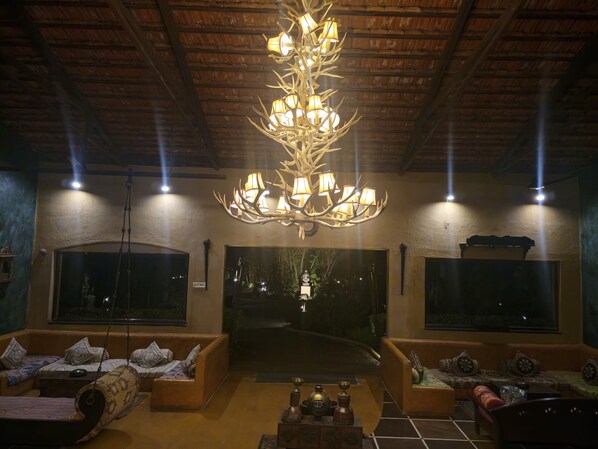 Una habitación acogedora con una lámpara original, ventanas amplias y un mobiliario cómodo.