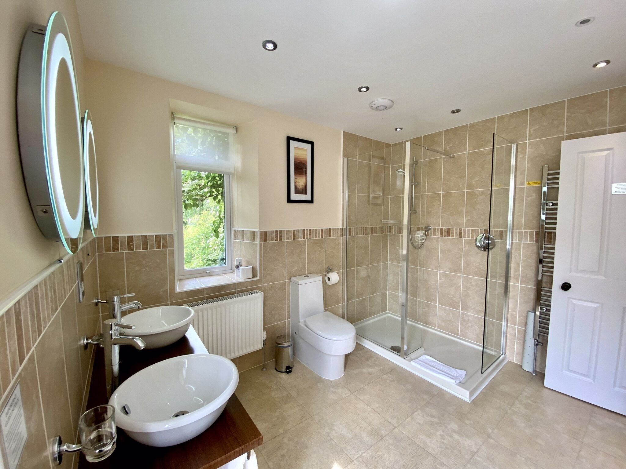 A modern bathroom with a sink, toilet, and glass-enclosed shower.