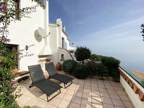 A terrace with two lounge chairs, a satellite dish, and a view of the sea. - Holiday rental semidetached with swimming pool in Begur, Sa Tuna (Begur)