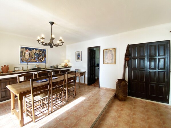 A spacious kitchen with a large wooden table and chairs, a chandelier, and various kitchen items. - Holiday rental semidetached with swimming pool in Begur, Sa Tuna (Begur)