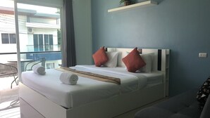 Un dormitorio moderno con una cama grande, una mesita de noche pequeña, una silla y un balcón con vistas.